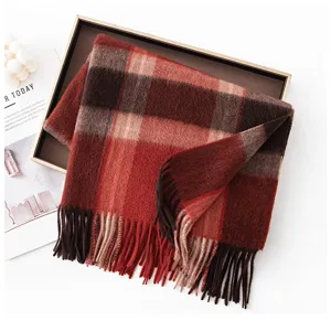 Detailed shot of a cozy red plaid cashmere scarf with fringes in a stylish tray display.