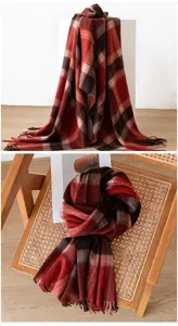 Cashmere plaid scarf detail shot showing soft texture, cozy red pattern, and fringe edge.