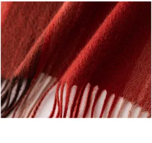 Close-up detail of the soft anchor red cashmere scarf showing fine texture and stylish fringe.