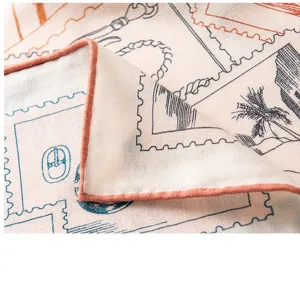 Silk wool square scarf detail showing vintage stamp pattern and refined rolled hem edges.
