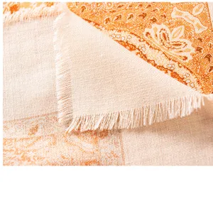 Close-up detail of women silk wool scarf featuring retro paisley print and fine fringe edges.
