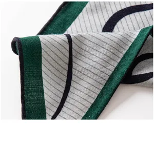 Silk wool triangle scarf for women, elegant grey striped design with green border.