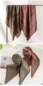 Gros plan détaillé du foulard carré en soie et laine rayé double face aux tons élégants.