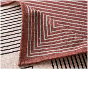 Detail d'echarpe en melange soie et laine avec rayures marron et motifs geometriques chics.