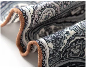 Detailed shot of a women's vintage paisley print neck scarf with neat brown rolled hem.