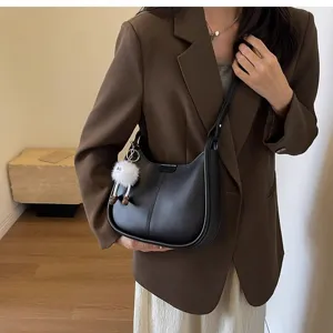 Stylish black leather shoulder bag with cute plush charm, perfect for autumn winter fashion.