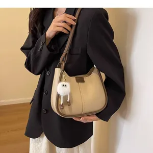 Detailed view of the stylish beige underarm shoulder bag with cute plush fluffy pendant.