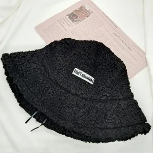 Detailansicht des schwarzen Sherpa-Fischerhuts mit gesticktem Aufnäher und weichem Fleece.