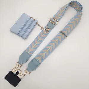 Blue wide bag strap with embroidered leaf pattern, detachable coin purse and phone tab accessory.