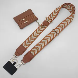 Wide bag strap with embroidered leaf pattern, detachable coin purse and phone tether tab.