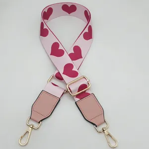 Adjustable pink heart print bag strap replacement with gold hardware for crossbody bags.