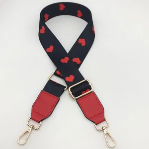 Detailed view of the black and red heart patterned replacement bag strap with gold hardware.