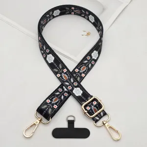 Close-up of bohemian style embroidered phone strap details with durable metal hardware and black tether tab.