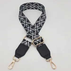 Black and white geometric pattern replacement bag strap detail with gold metal hardware and clips.