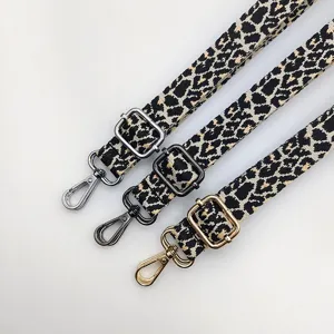 Gros plan détaillé de sangles de sac réglables à motif léopard avec mousquetons métalliques.