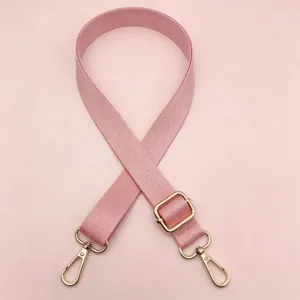 Gedetailleerd overzicht van een roze nylon vervangende tasband met gouden hardware en lengte.