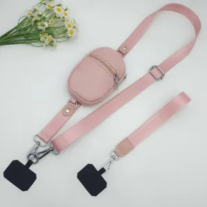 Pink mini crossbody coin purse with adjustable nylon shoulder strap and phone lanyard attachments.