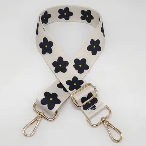 Courroie de sac de rechange réglable avec joli motif de fleurs noires et quincaillerie dorée.