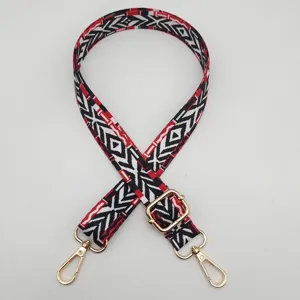 Detailaufnahme des bunten, geometrischen Taschenriemens mit verstellbaren Goldbeschlägen.
