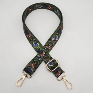 Vista detallada de la correa de bolso de repuesto estampada con mariposas verdes de estilo étnico.