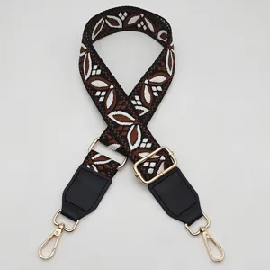 Tracolla di ricambio larga regolabile con motivo jacquard, ecopelle e minuteria metallica dorata.