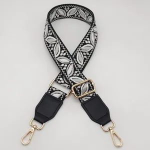 Sostituzione della tracolla della borsa in jacquard bianco e nero con hardware dorato.