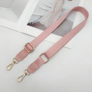 Verstelbare roze nylon tasriem met gouden hardware als handige crossbody accessoire.