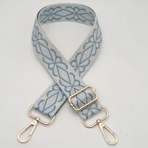Tracolla di ricambio intrecciata con ricamo geometrico blu e fibbie metalliche dorate regolabili.