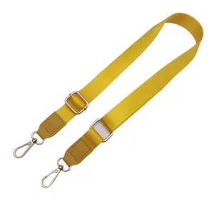 Verstelbare gele nylon tasriem met lederen uiteinden en metalen haken voor damestassen.