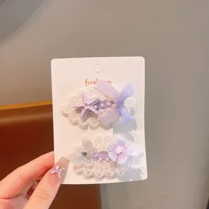 Detailed view of sweet purple lace hair clips with bows and star flower embellishments on card.
