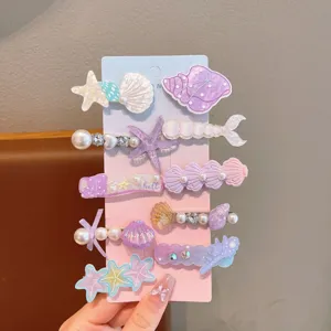 Detailed view of cute mermaid pearl hair clips set, adorable shell and starfish design for girls.