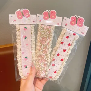 Detailaufnahme von drei süßen Kinder Ponyhaar Klettverschlüssen mit Erdbeer und Blumen.
