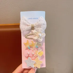 Nahaufnahme des Kinder Perlen und Muschel Haarnadel Sets mit süßer Schleife und Sternfisch.