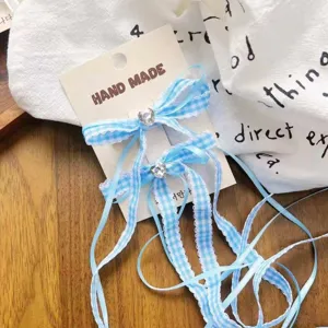 Detalle de pinza de pelo lazo estrás cuadros azul, accesorio de pelo bonito y dulce.