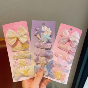 Detailed view of cute children hair clips set with mermaid shell and bow designs on cards.