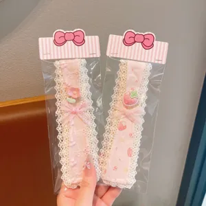 Close-up detail of sweet pink lace bangs hairband with cute strawberry and bow decorations.