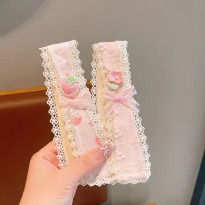 Close-up detail of sweet pink lace hair bangs patch with cute strawberry and bow charms.