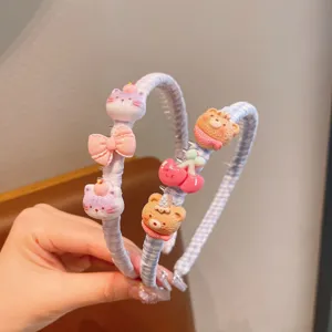 Vue détaillée du cerceau à cheveux à carreaux mignon pour enfants avec des breloques.