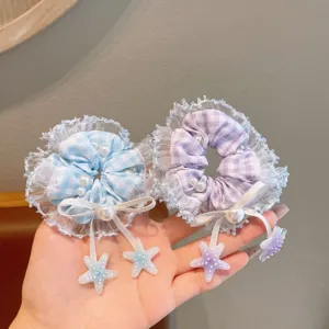 Detailed view of sweet lace hair scrunchies in blue and purple with pearls and star pendants.