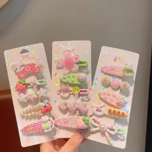 Dettaglio di simpatici fermagli per capelli, design floreali e di fragole rosa per bambini.
