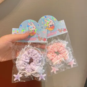 Close-up detail of Korean style lace plaid hair scrunchies with pearls and star charms.