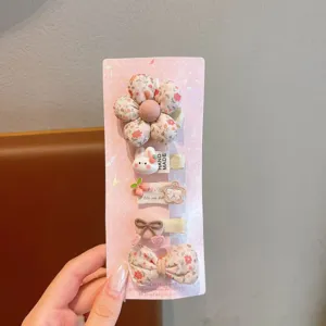 Detailed view of cute children hair clip set, fabric cartoon floral bow hairpins for girls.