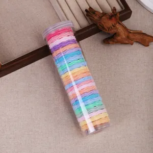 Colorful hair scrunchies in a clear plastic storage tube, high elastic rubber bands for daily hair styling.