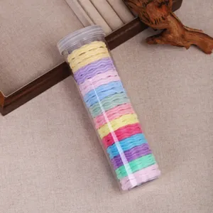 Detailed shot of colorful hair ties in a clear plastic tube, elastic hair bands for daily styling.
