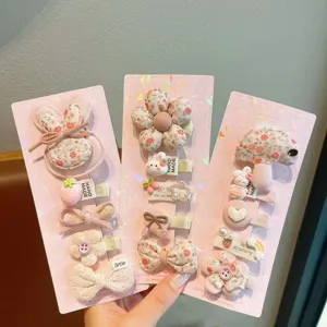 Cute cartoon hair clip set detail showing soft fabric rabbit and flower designs on pink cards.
