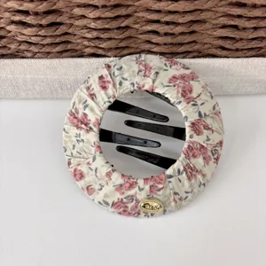 Floral fabric round hair clip detail shot, elegant vintage hair accessory for daily styling use.