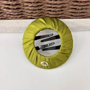 Green satin hair bun maker detail, elegant hair styling clip accessory for women and girls.