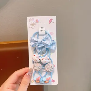 Detailed view of kids hair ties set with blue plaid bows and cute cartoon charms on card.