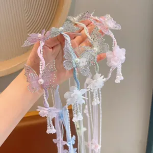 Close-up detail of children pastel butterfly flower headband with hanging pearl tassel ribbons.