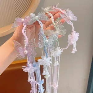 Detailed close-up of butterfly rhinestone hair vine with pearls and pastel streamers for kids.